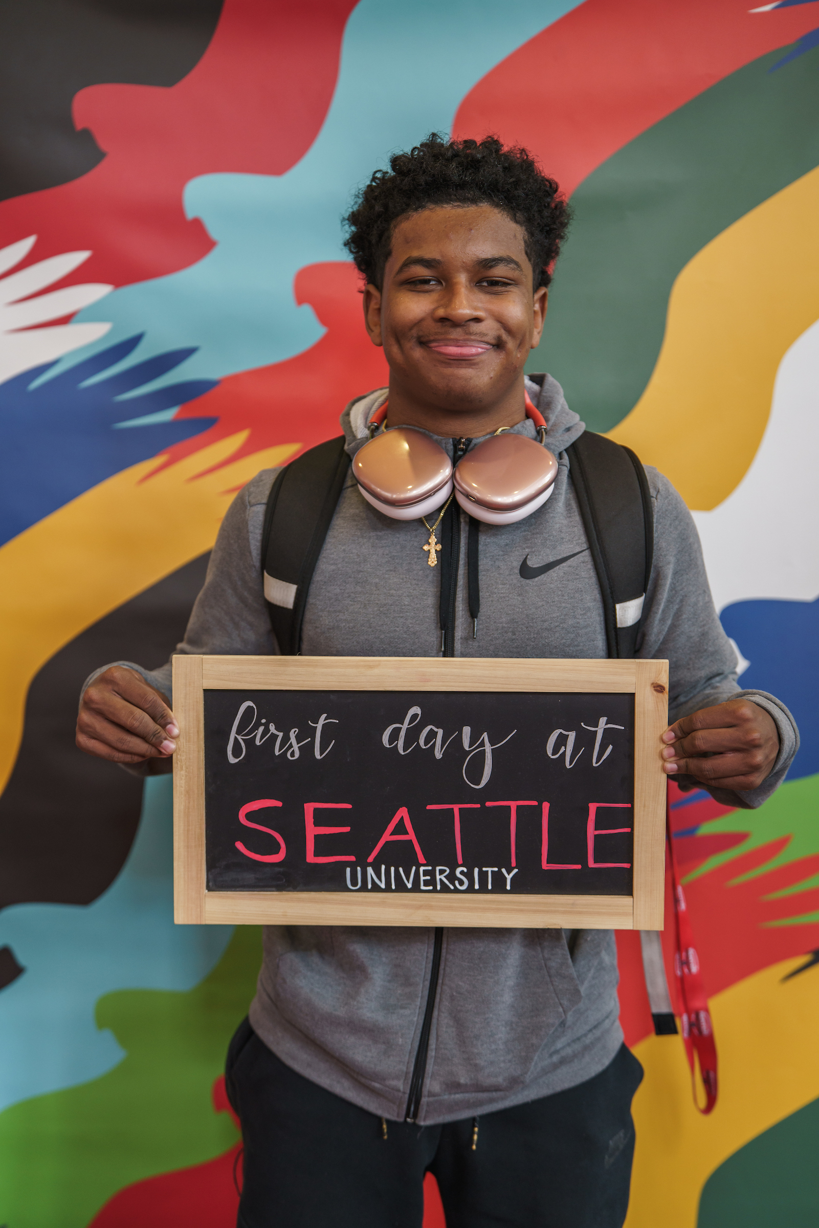 Photo of a student standing with a chalkboard that says "First Day at Seattle U"